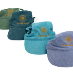 Corduroy dog hats with bills from the Live Life Golden collection in green, blue, teal, and purple, featuring sunburst embroidery.