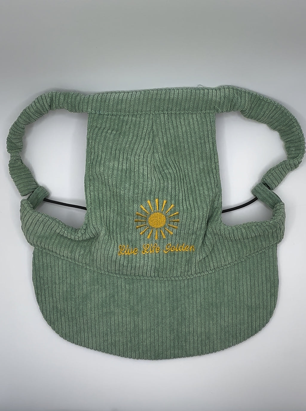 Green corduroy dog hat with ear holes and sun embroidery reading ‘Live Life Golden.’
