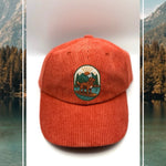 Red corduroy human hat with the Kodiak paddleboard adventure iron on patch inspired by outdoor living.