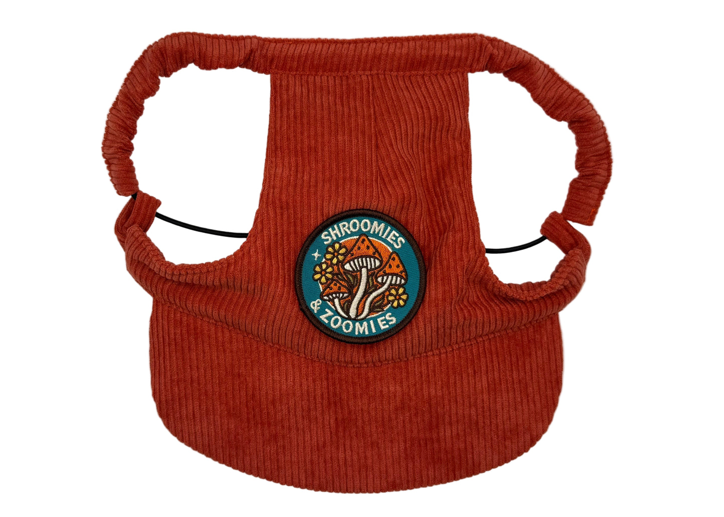 Rust-red corduroy dog hat featuring a colorful “Shroomies & Zoomies” mushroom patch — designed with adjustable straps, a curved brim, and soft corduroy texture from The Golden Life Golden Gala collection.