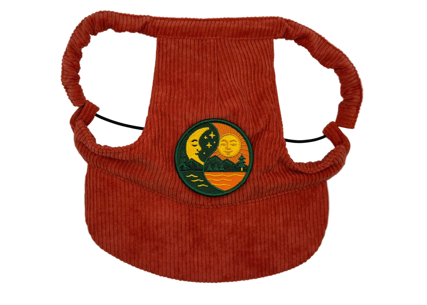 Rust-red corduroy dog hat featuring a Yin & Yang Sun and Moon patch — symbolizing balance between day and night. Designed with adjustable straps, a curved brim, and soft corduroy texture from The Golden Life Golden Gala collection.

