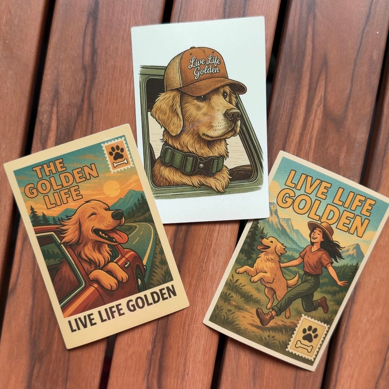 Three custom golden retriever vinyl stickers in vintage outdoor style placed on wooden surface, Live Life Golden designs