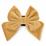 Gold velvet dog bow in golden hour color on a white background